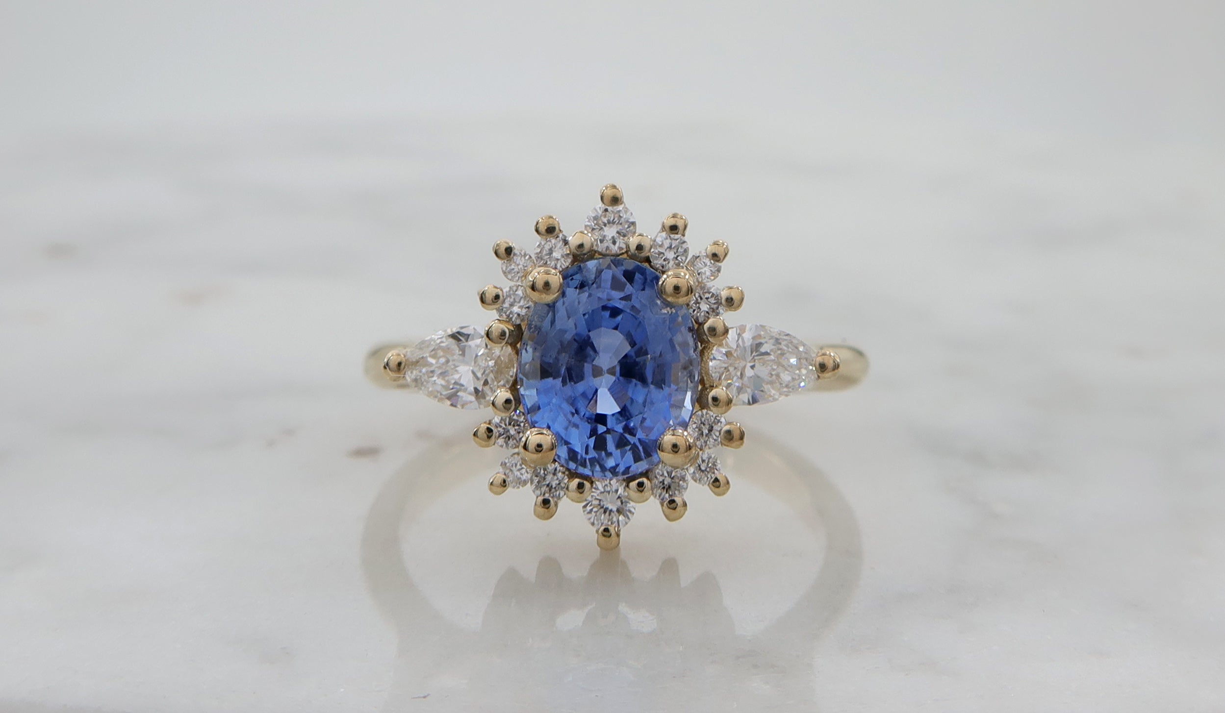 טבעת Halo משובצת אבן ספיר אובלית ויהלומים מסביב