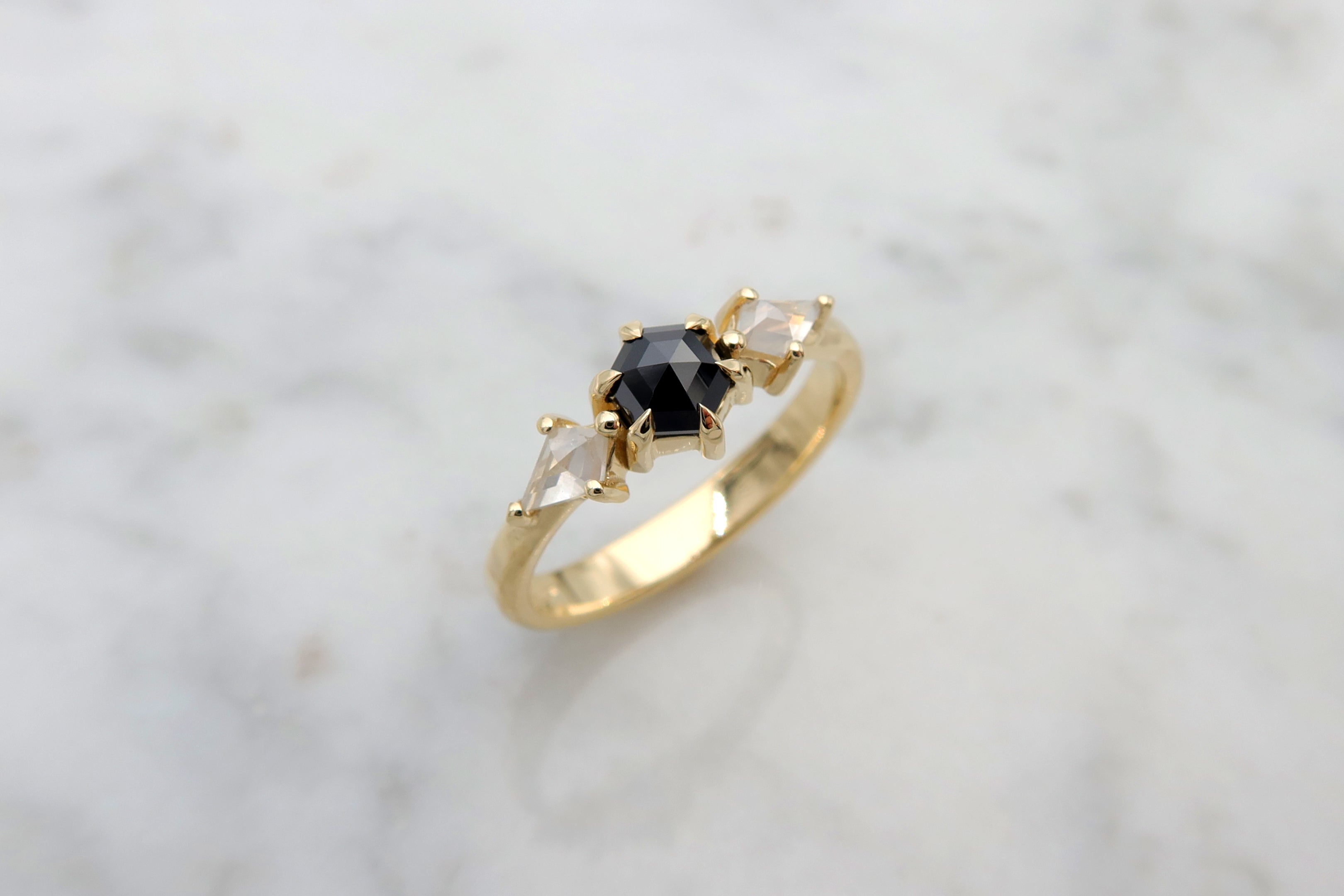 טבעת משובצת יהלום שחור בחיתוך משושה בשילוב יהלומים לבנים